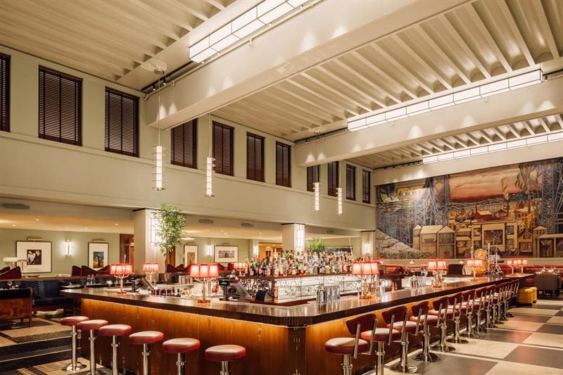 Firkantet bar i sentrum av rommet, freske av Per Krogh langs veggen i enden.